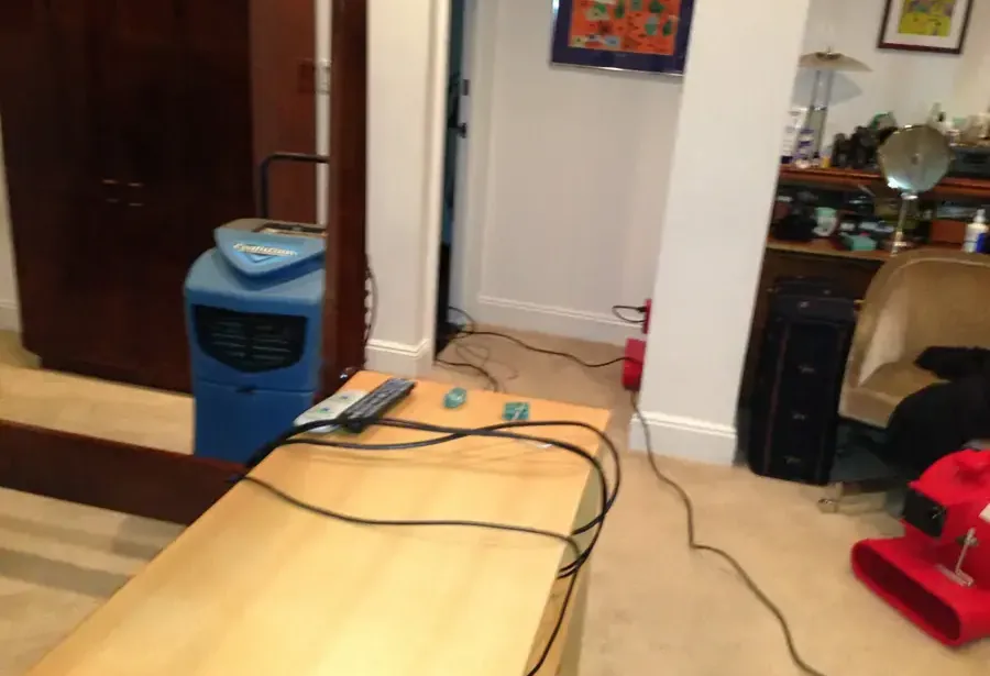 A dehumidifier and an air mover drying a room after a water loss