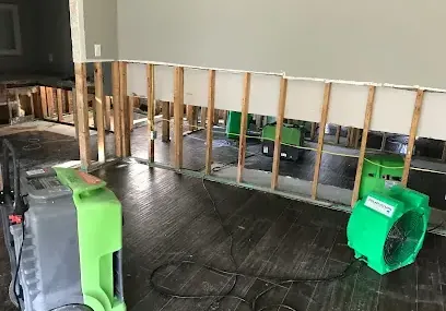 A flood cut along the lower wall with air movers drying the exposed framing