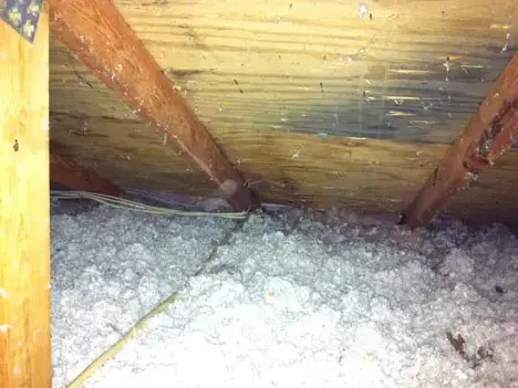 Water-stained roof sheathing and damp insulation in an attic